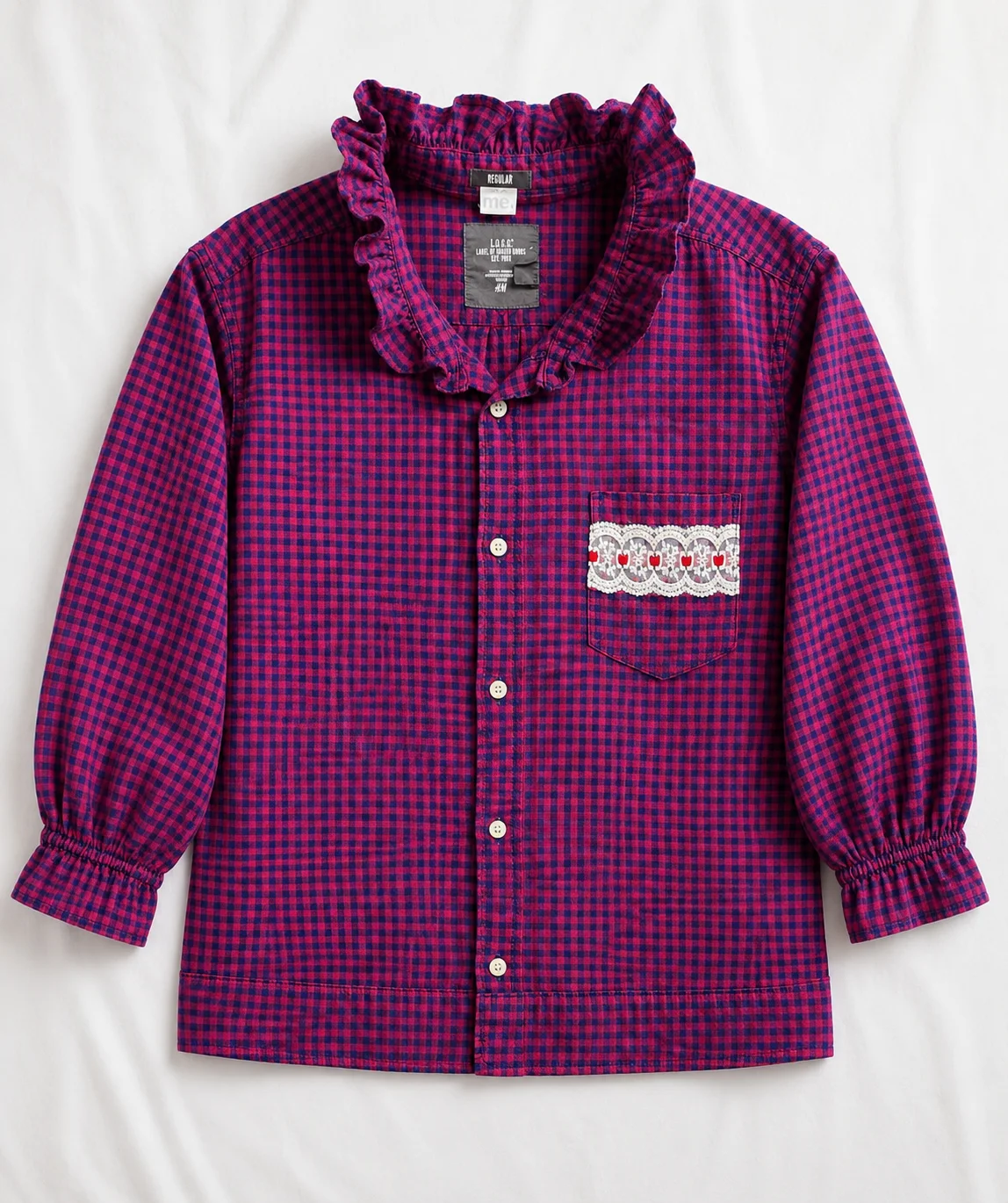 Cameron — raspberry and navy gingham shirt with ruffled collar and neckline, gathered cuffs and lace heart pocket detail, flat lay
